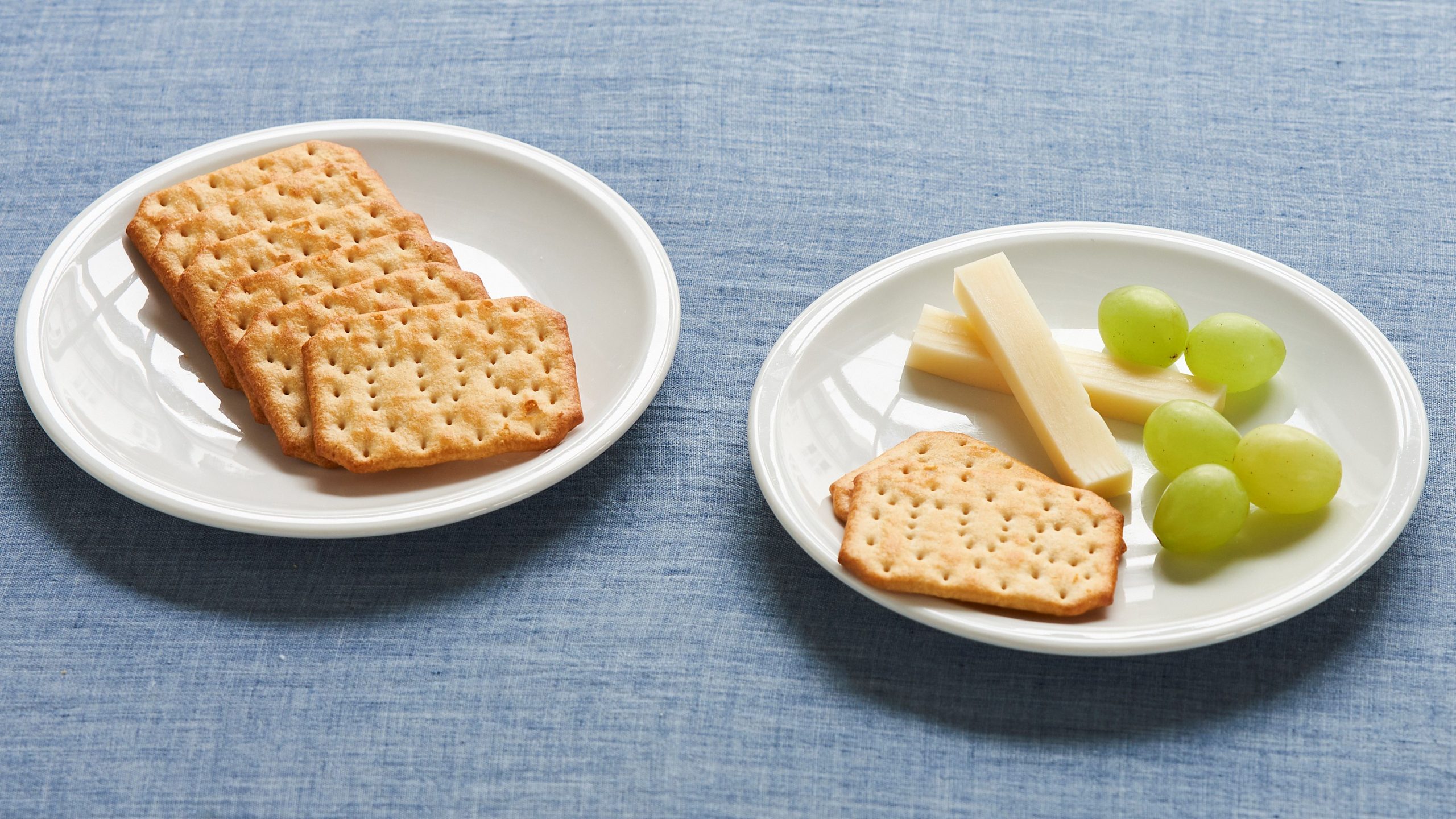 Mellemmåltid med kiks, ost og vindruer.